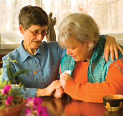 Sister Anne Maureen Doherty, C.B.S. comforts a woman after the death of a family member.