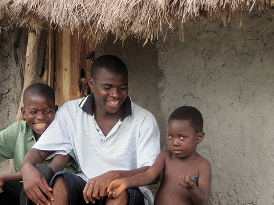 Brother Fabian Jongwe, S.C. plays with children during a break from his efforts to purchase corn to feed boarders at the school.