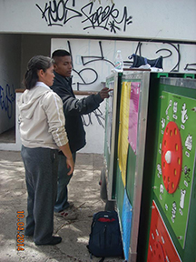 Sister Lupita Silva, C.D.P. helps an older student understand a lesson he did not master at school. 