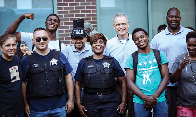 Along with area residents and local police, Father Dave Kelly, C.PP.S. takes part in an event called Light the Night, a community gathering with food, sports, and socializing. 