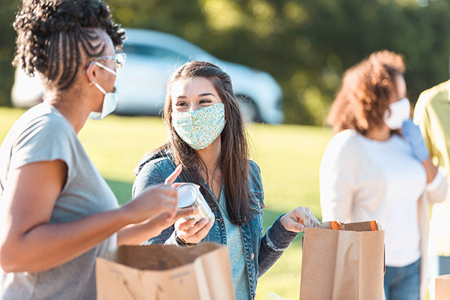 Young women work at a food drive