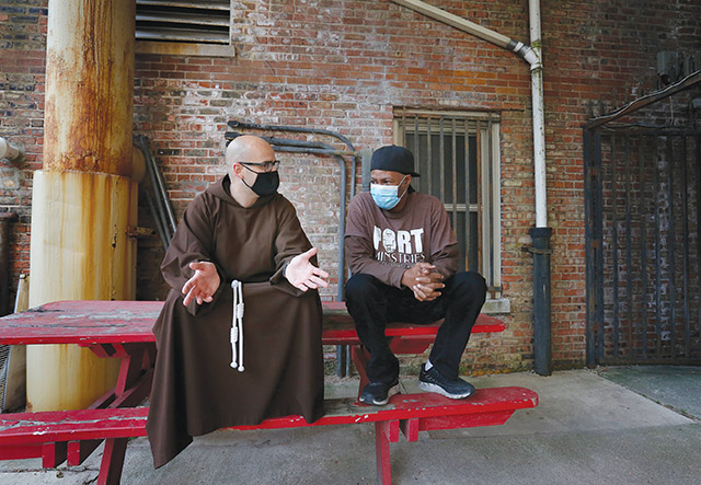 Father M.J. Groark, O.F.M.Cap. chats with Anthony Brown, bread truck coordinator for Port Ministries in Chicago.