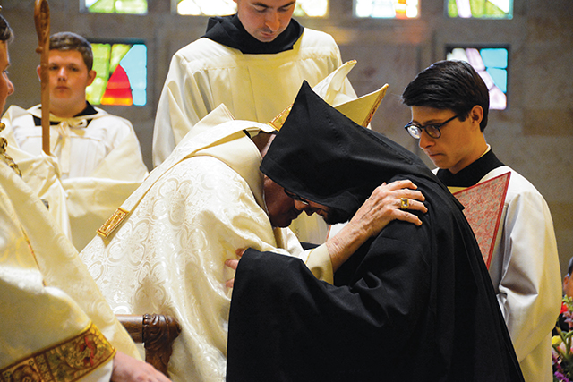 The abbot clothes a newly professed monk with the cuculla after his solemn vows.