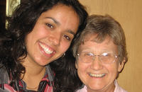 Younger and older sister smiling together