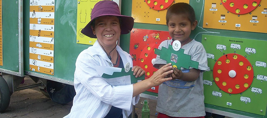 A young Escuela Móvil student is proud of his work, and Sister Ely Carrasco, C.D.P. is just as proud of him.