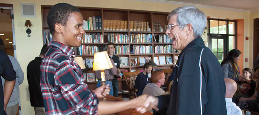 Lionell Daggs III greets Jesuit Father Stephen Privet, S.J. at an event at the University of San Francisco.