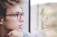 Young man gazing out window