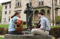 Students play guitar in front of a statue of Saint Martin de Porres on the campus of Providence College, Rhode Island.