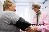 Sister Carole Blazina, S.C. performs a blood pressure check. 