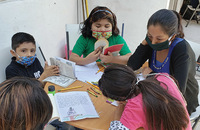 Alejandra Candia Tapia (top right) serves as a volunteer at Cuernavaca Children’s Mission , on this day helping children write book reports.