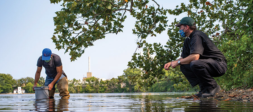 Father Terry Ehrman, C.S.C. with a student from his aquatics biology class collecting water samples. 