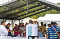 Glenmary Home Missioners celebrate Mass with migrant workers in a carport