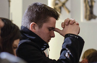 young man praying in church